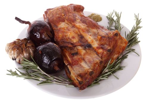 Grilled pork ribs with onions, garlic and rosemary on a plate, isolated on white background