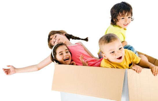 Group of four happy kids having fun inside cardboard, isolated on white