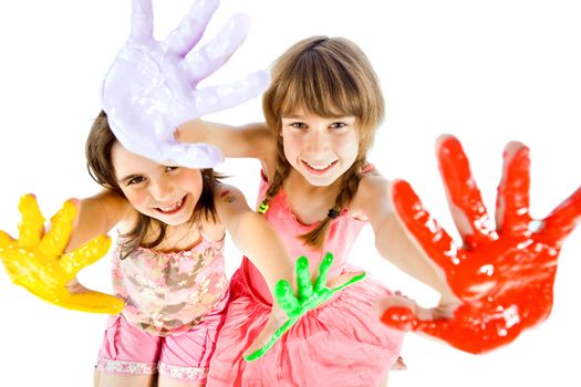 Two happy little girls showing their painted colorful hands to the camera