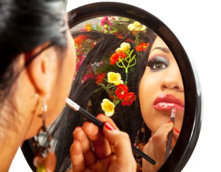 reflection in a mirror of a beautiful hispanic female applying lipstick