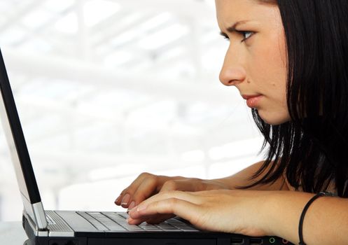 close-up of a female working profoundly on a laptop, serious