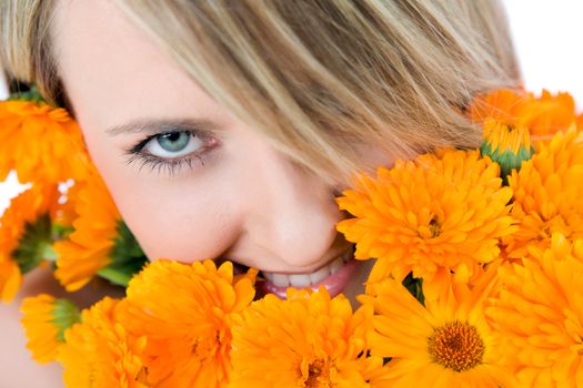 Close-up of beautiful female face holding marigolds, colourfull eye looking at camera