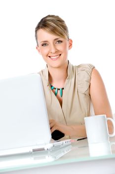 Beautiful smiling woman sitting on desk behind laptop and cup