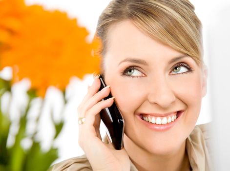 Close-up of beautiful female smiling and talking on cell phone, looking up