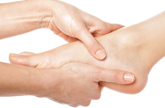 woman hands giving a foot massage on white background