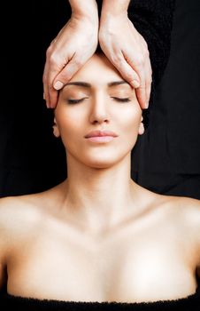Beautiful female receiving relaxing facial massage at spa, eyes closed