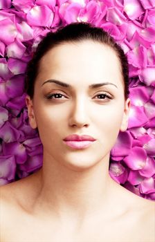 portrait of a beautiful young woman on pink rose petals
