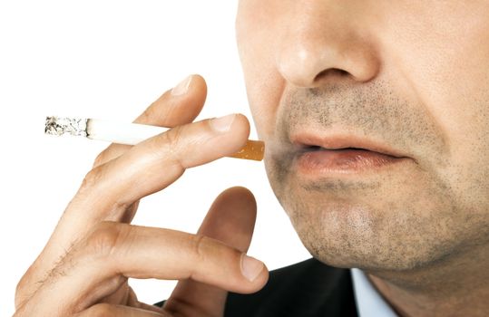 Cropped image of man holding cigarette in his hand, close-up on it and mouth