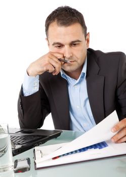 Portrait of businessman holding pen in hand, reading documents