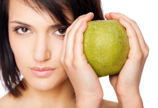 Beautiful female holding granny smith apple with both hands, focus on fruit