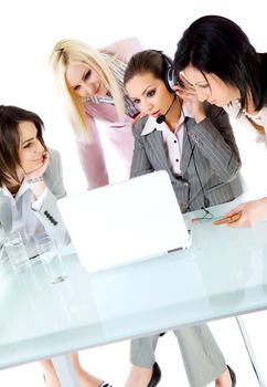 Team of four successful businesswomen working behind laptop, one with headset, vertical