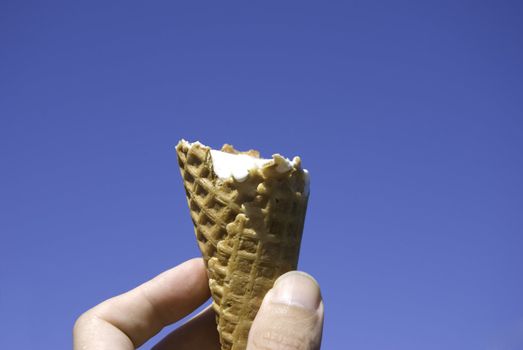 summer concept, ice--cream inn the hand on blue sky background