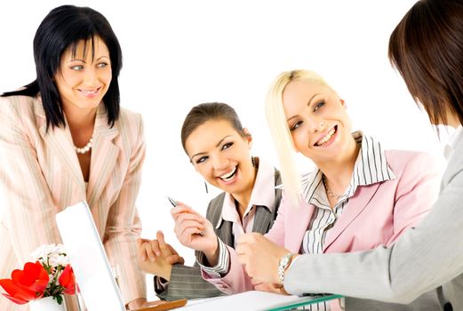 Team of four successful businesswomen working and smiling behind laptop