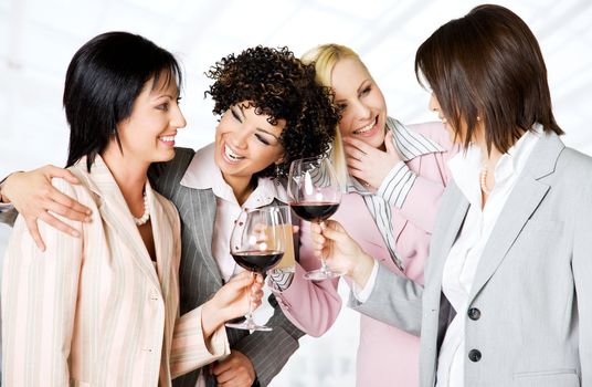 Team of four happy businesswomen looking each other celebrating