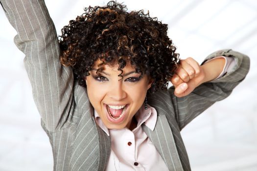 Beautiful happy woman with curly hair raising her arms with excitement