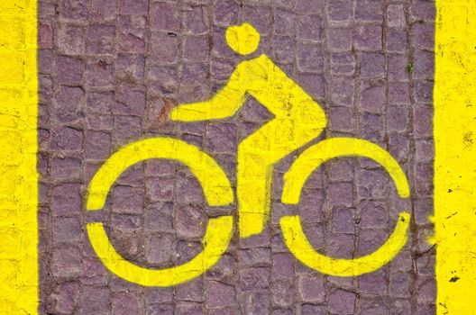 horizontal yellow bicycle line sign on the pavement