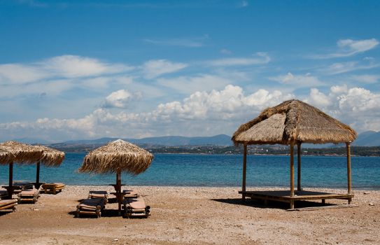 Beautiful beach with lounge chairs and straw umbrellas, Greece sea