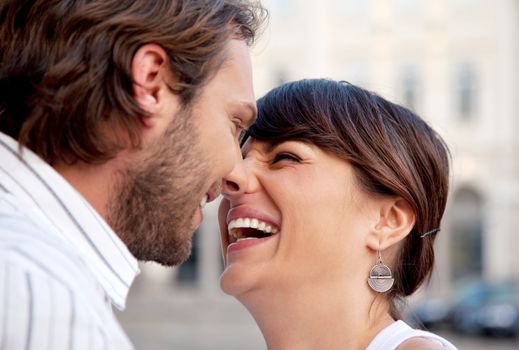 beautiful female and attractive male kissing and laughing