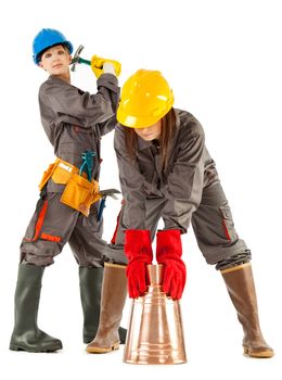 Two female construction workers posing with instruments, isolated