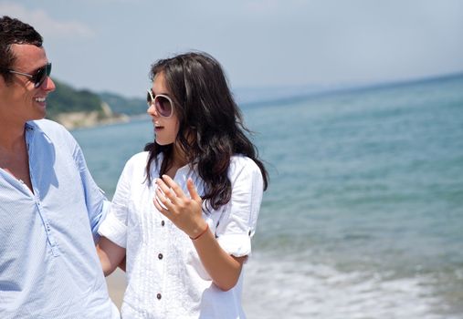 Young happy couple hugging and talking on the beach