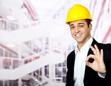 portrait of a happy architect with helmet, showing OK sign