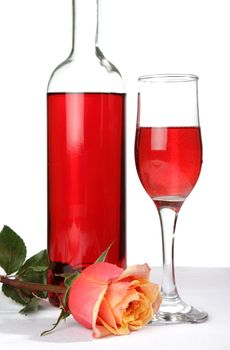 pink wine bottle glass and rose on a table isolated