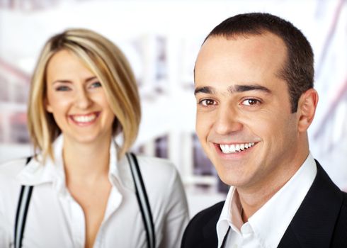 Business couple smiling looking at camera male on focus