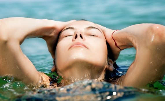 Close-up of young female face enjoying sea water