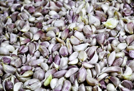 A close-up of a basket full of Garlic cloves at a market