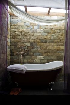 A decorative Bathtub with brown brick walls