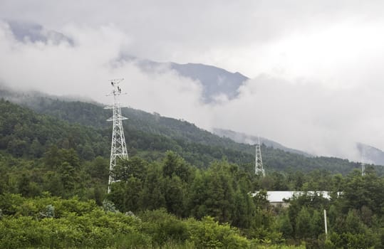 Men working on power line towers on a hillside in China