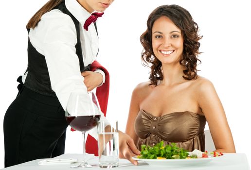 Beautiful female smiling and sitting in restaurant, being served salad by waitress