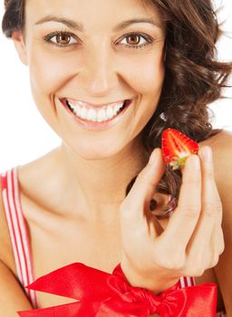 Portrait of beautiful happy woman with a cut strawberry in hand