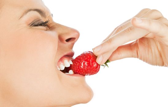 Profile of a young female biting fresh strawberry, isolated on white