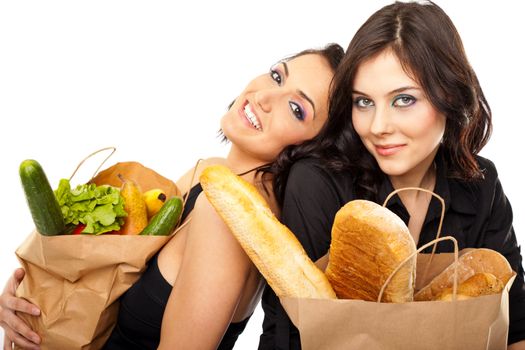Two beautiful girlfriends posing with grocery bags isolated