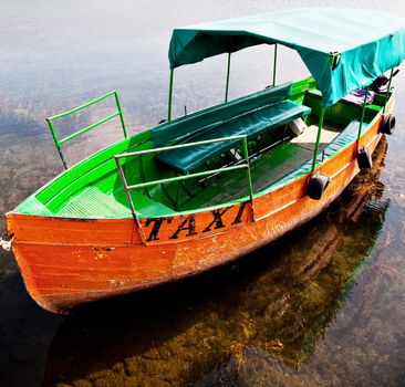 an orange motorboat in the lake of Ohrid with a taxi sign