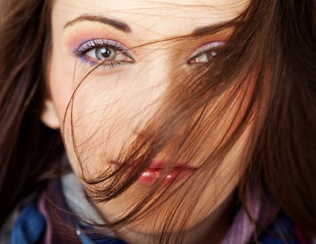 Close-up of a beautiful female face with hair blown over her face