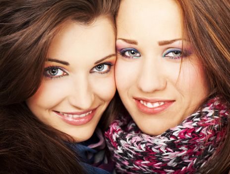 Close-up of two young beautiful girlfriends smiling