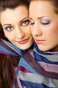 close-up of two young female faces with colourful makeup