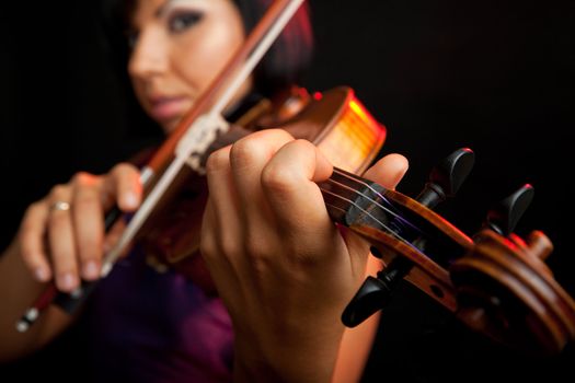 young beautiful female violinist, focus on her fingers