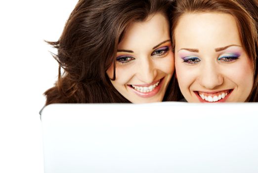 Two beautiful young women using a laptop smiling