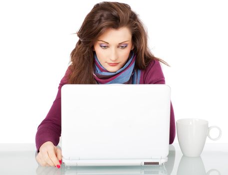 Young beautiful female sitting behind white laptop with a cup