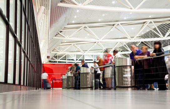 arrival section at airport with blurred figures of waiting people