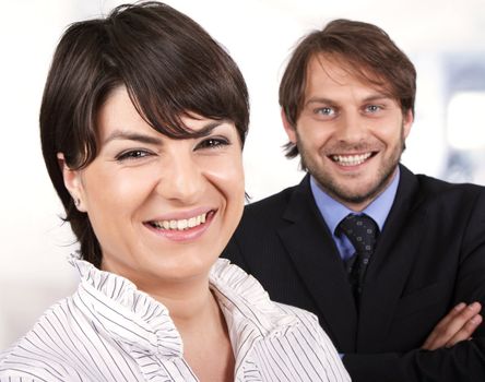 smiling business people. female infront of a male