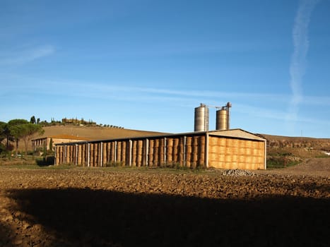 Piles of straw bales stacked in a shed on an italian farm.