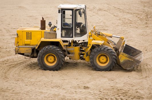 grunge and dirty tractor on sand surface (focus poit on machine selective)

