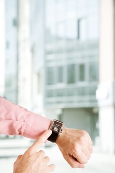 hands of the man with clock on urban background