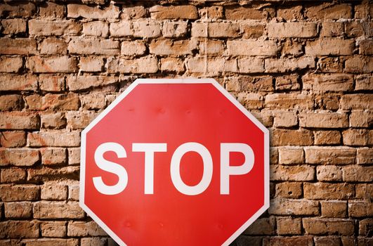 simple concept with red road sign and brick wall