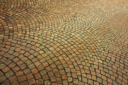 Detail of a patterned cobbled courtyard stretching away into the distance.