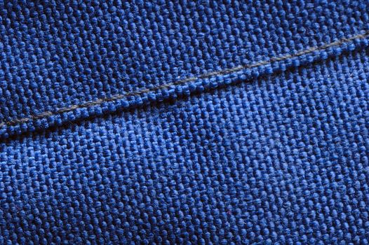 Macro of a seam in blue woven fabric.